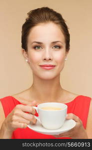 leisure, happiness and drink concept - smiling woman in red dress with cup of coffee