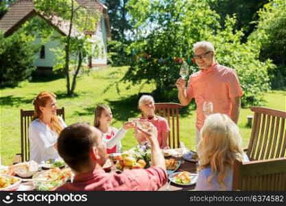 leisure, holidays and people concept - happy family having festive dinner at summer garden and celebrating. family gathering at summer garden and celebration