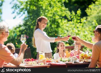 leisure, holidays and people concept - happy family having festive dinner or summer garden party and celebrating. happy family having dinner or summer garden party