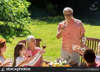 leisure, holidays and people concept - happy family having festive dinner or summer garden party and celebrating. happy family having dinner or summer garden party