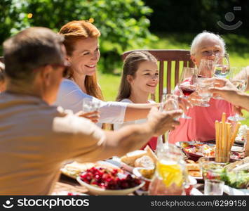 leisure, holidays and people concept - happy family having festive dinner or summer garden party and celebrating. happy family having dinner or summer garden party