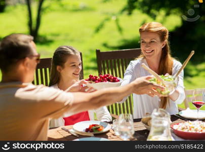 leisure, holidays and people concept - happy family having festive dinner or summer garden party. happy family having dinner or summer garden party