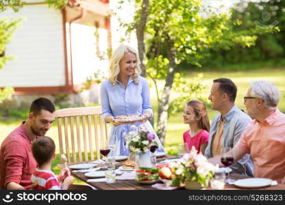 leisure, holidays and people concept - happy family having festive dinner or summer garden party. happy family having dinner or summer garden party