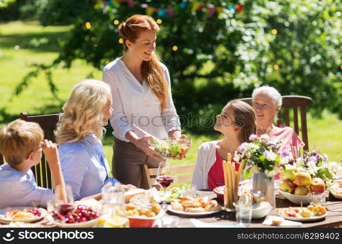 leisure, holidays and people concept - happy family having festive dinner or summer garden party. happy family having dinner or summer garden party