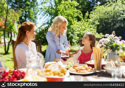 leisure, holidays and people concept - happy family having festive dinner or summer garden party. happy family having dinner at summer garden
