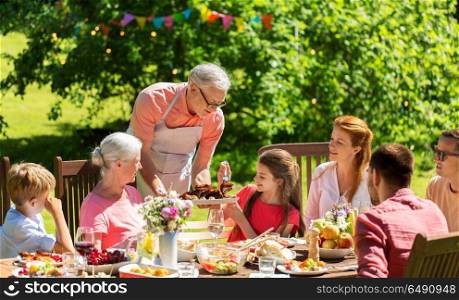 leisure, holidays and people concept - happy family having festive dinner or summer garden party. happy family having dinner or summer garden party. happy family having dinner or summer garden party