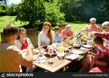 leisure, holidays and people concept - happy family having festive dinner or summer garden party. happy family having dinner or summer garden party. happy family having dinner or summer garden party