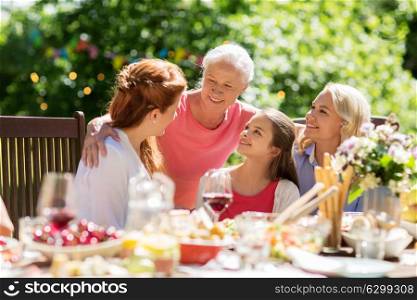 leisure, holidays and people concept - happy female family having festive dinner or summer garden party. happy family having dinner or summer garden party