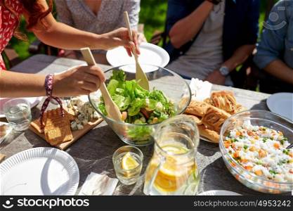 leisure, holidays, eating, people and food concept - friends having dinner at summer garden party. friends having dinner at summer garden party