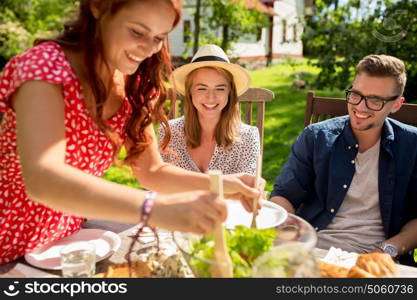 leisure, holidays, eating, people and food concept - happy friends having dinner at summer garden party. happy friends having dinner at summer garden party