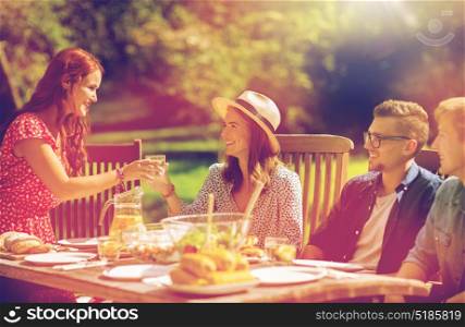 leisure, holidays, eating, people and food concept - happy friends having dinner at summer garden party. happy friends having dinner at summer garden party