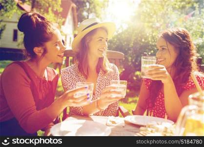 leisure, holidays, eating, people and food concept - happy women or friends with drinks celebrating reunion and having dinner at summer garden party. happy women with drinks at summer garden party