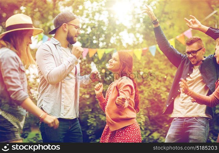 leisure, holidays, fun and people concept - happy friends dancing at summer party in garden. happy friends dancing at summer party in garden