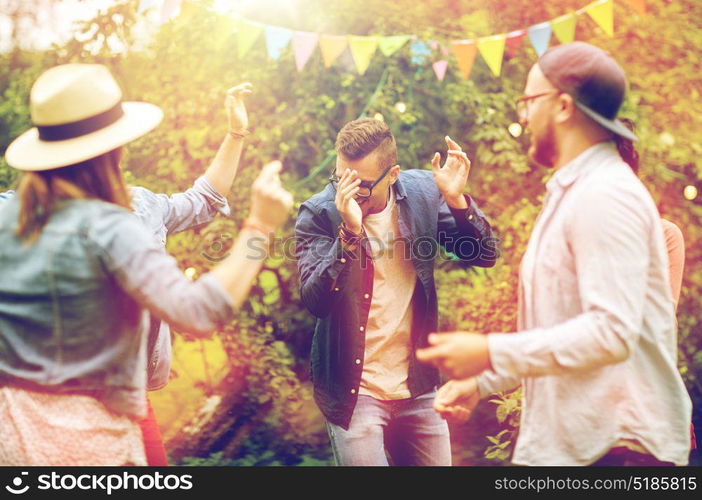 leisure, holidays, fun and people concept - happy friends dancing at summer party in garden. happy friends dancing at summer party in garden