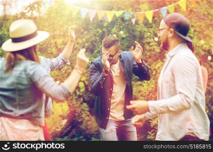 leisure, holidays, fun and people concept - happy friends dancing at summer party in garden. happy friends dancing at summer party in garden