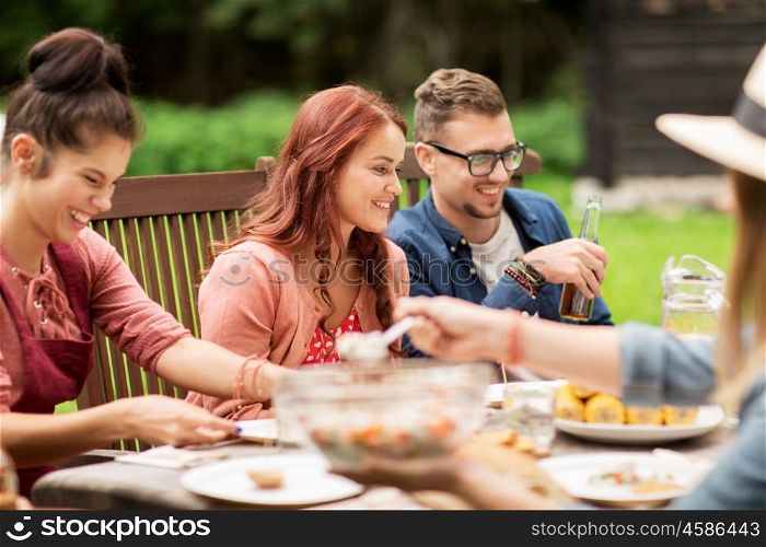 leisure, holidays, people and food concept - happy friends having dinner, eating and drinking at summer garden party