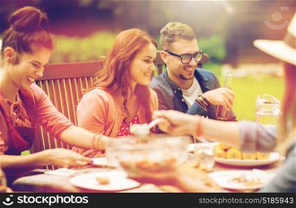 leisure, holidays, people and food concept - happy friends having dinner, eating and drinking at summer garden party. happy friends having dinner at summer garden party