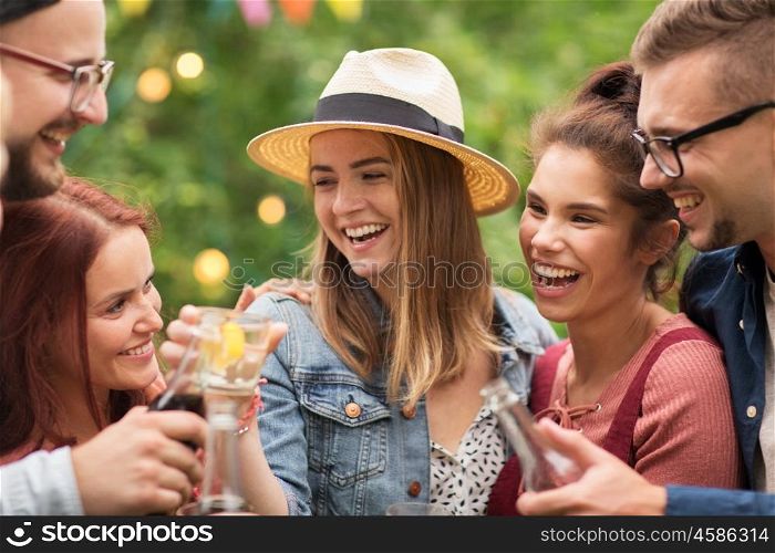 leisure, holidays, people, reunion and celebration concept - happy friends clinking glasses and celebrating at summer garden party