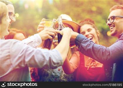 leisure, holidays, people, reunion and celebration concept - happy friends clinking glasses and celebrating at summer garden party. happy friends clinking glasses at summer garden