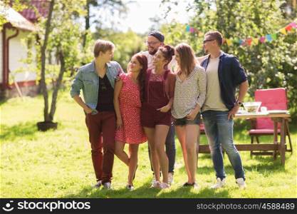 leisure, holidays, reunion, people and friendship concept - happy teenage friends hugging at summer garden party