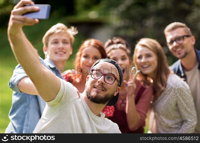 leisure, holidays, reunion, people and friendship concept - happy teenage friends taking selfie by smartphone at summer