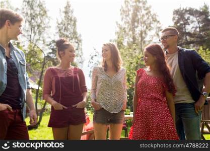 leisure, holidays, reunion, people and friendship concept - happy teenage friends talking at summer garden