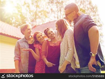 leisure, holidays, reunion, people and friendship concept - happy teenage friends talking at summer garden. happy teenage friends talking at summer garden