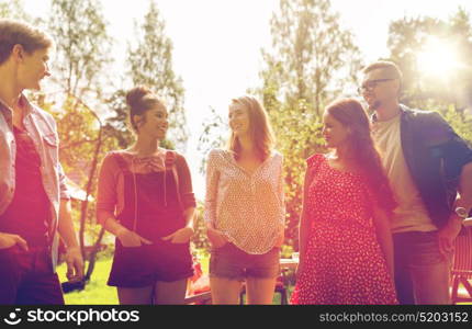 leisure, holidays, reunion, people and friendship concept - happy teenage friends talking at summer garden. happy teenage friends talking at summer garden