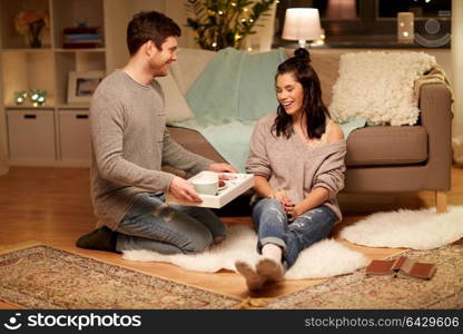 leisure, hygge and people concept - happy couple with food on tray at home. happy couple with food on tray at home