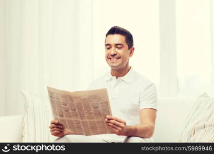 leisure, information, people and mass media concept - happy man reading newspaper at home