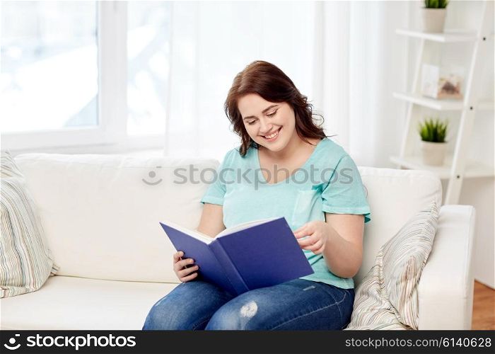 leisure, literature and people concept - smiling young plus size woman reading book at home