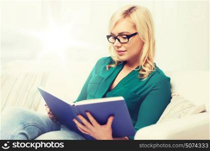 leisure, literature, education and people concept - young woman in glasses reading book at home. young woman in glasses reading book at home