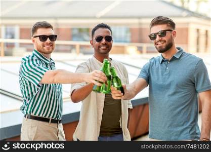 leisure, male friendship and people concept - happy men or friends drinking beer at rooftop party in summer. happy male friends drinking beer at rooftop party