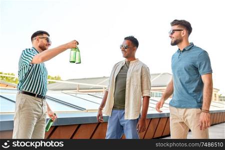 leisure, male friendship and people concept - happy men or friends drinking beer at rooftop party in summer. happy male friends drinking beer at rooftop party