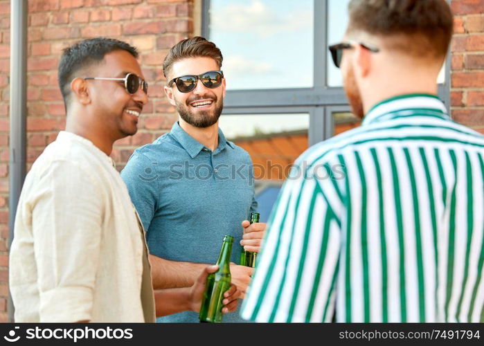 leisure, male friendship and people concept - happy men or friends drinking beer and talking in summer city. happy male friends drinking beer in summer city