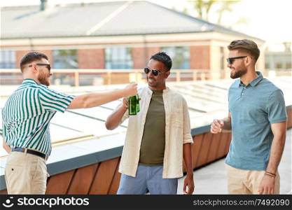 leisure, male friendship and people concept - happy men or friends drinking beer and talking at rooftop party in summer. happy male friends drinking beer at rooftop party