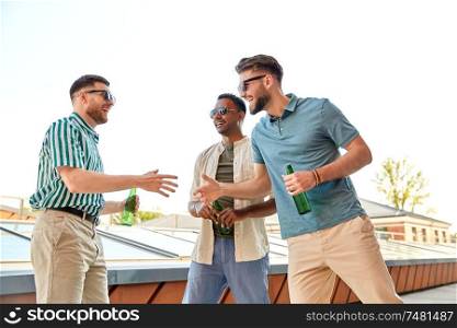 leisure, male friendship and people concept - happy men or friends meeting and drinking beer at rooftop party in summer. happy male friends with beer meeting on rooftop