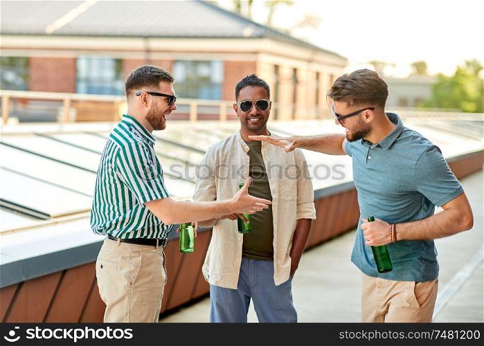 leisure, male friendship and people concept - happy men or friends with beer meeting at rooftop party in summer. happy male friends drinking beer at rooftop party