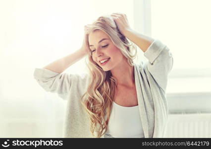 leisure, morning and people concept - happy young woman stretching at home. happy young woman stretching at home