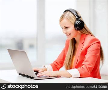 leisure, music, free time, online and internet concept - happy woman with headphones listening to music