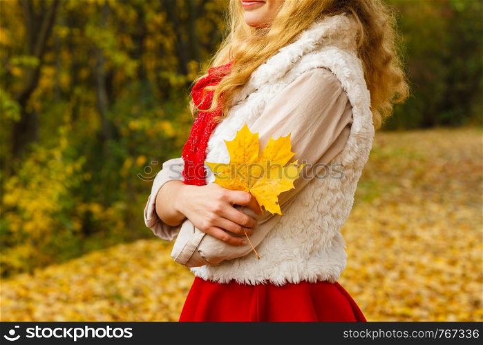 Leisure outdoor relax forest park autumn fall concept. Young lady holding leaf. Girl in park presenting maple foliage.. Young lady holding leaf.