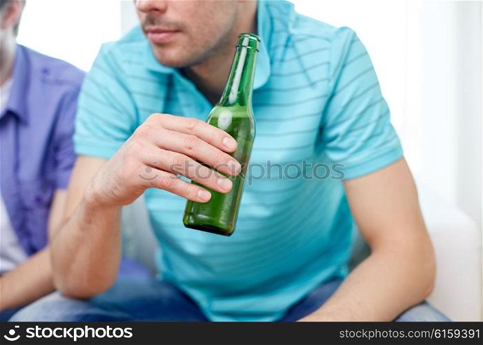 leisure, people and alcohol concept - close up of man drinking beer at home