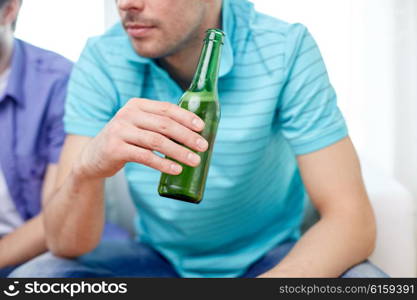 leisure, people and alcohol concept - close up of man drinking beer at home