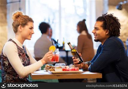 leisure, people and holidays concept - happy couple with drinks at restaurant or bar. happy couple with drinks at restaurant or bar