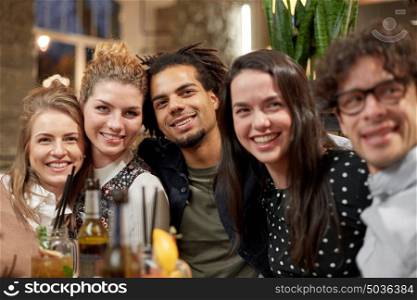 leisure, people and holidays concept - happy friends with drinks at bar or cafe. happy friends with drinks at bar or cafe