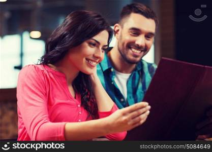 leisure, people and holidays concept - smiling couple with menus at restaurant. smiling couple with menus at restaurant. smiling couple with menus at restaurant