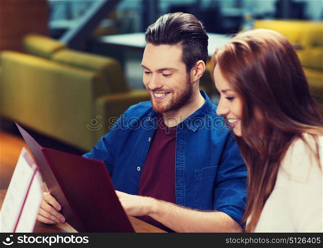 leisure, people and holidays concept - smiling couple with menus at restaurant. smiling couple with menus at restaurant