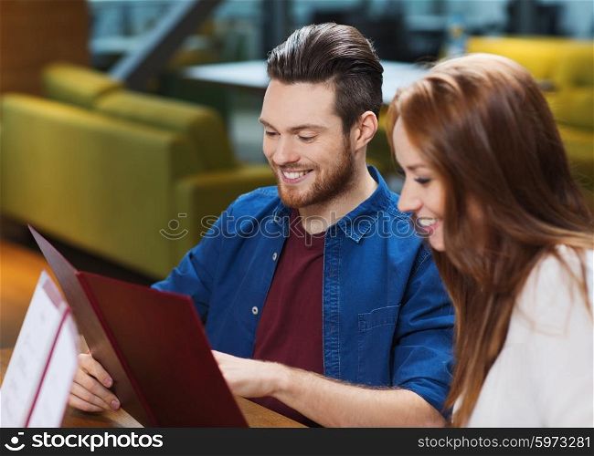 leisure, people and holidays concept - smiling couple with menus at restaurant
