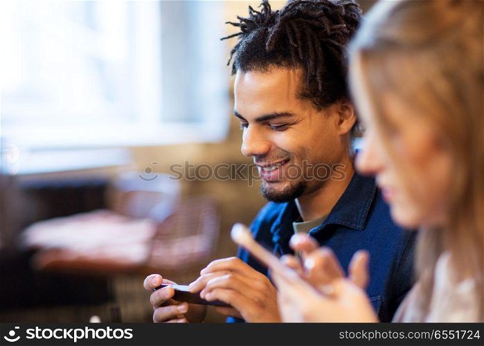 leisure, people and technology concept - happy young man with smartphone at bar. man with smartphone at bar. man with smartphone at bar