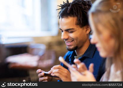 leisure, people and technology concept - happy young man with smartphone at bar. man with smartphone at bar. man with smartphone at bar